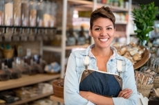 A small-business owner in front of their store