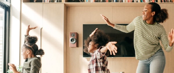 A mother and her kids dancing in their living room