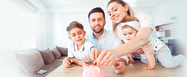 A young family saving coins in a piggy bank